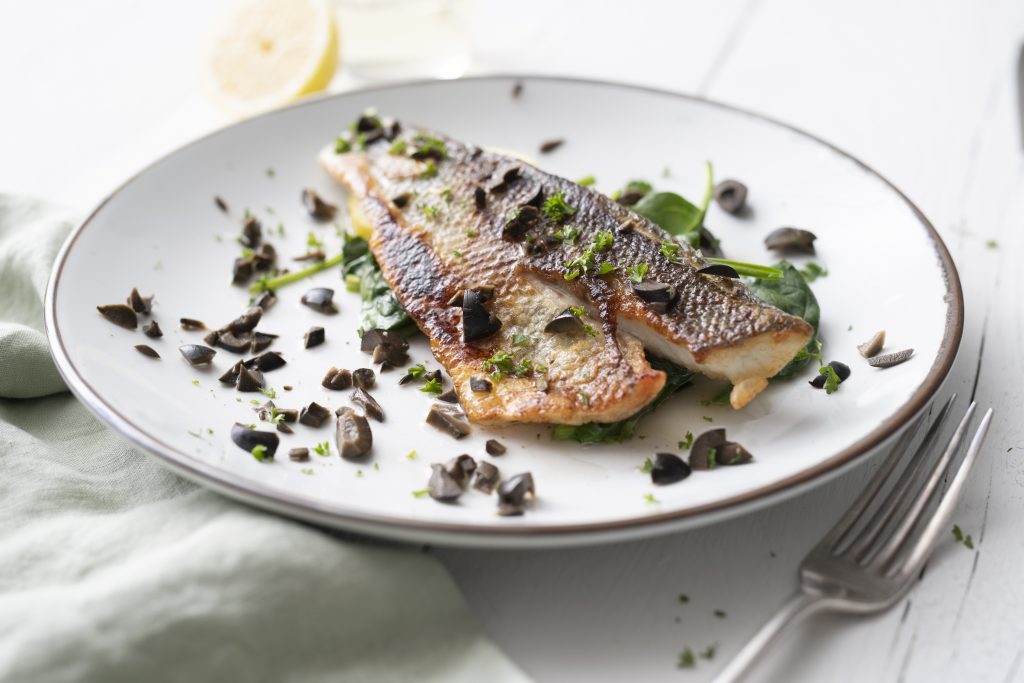 Zeebaars recept gebakken op de huid met spinazie en zwarte olijven